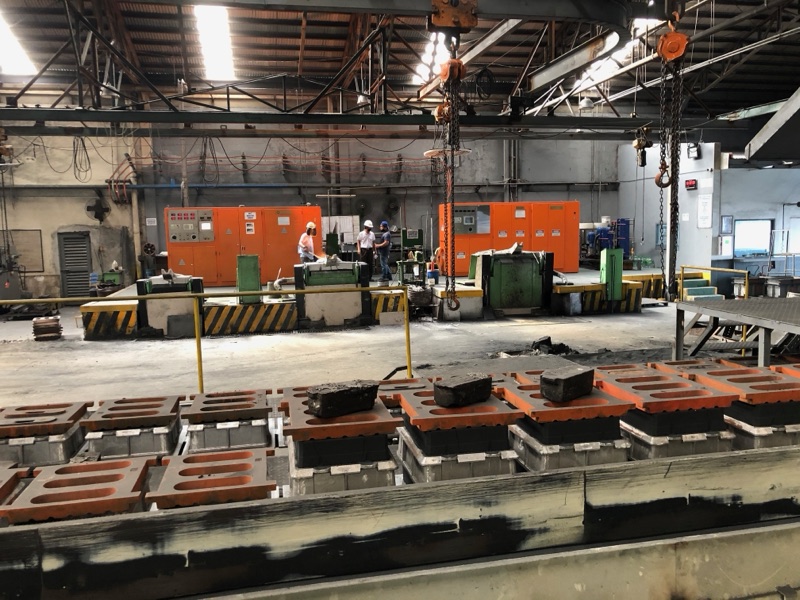 Pouring line of sand molds in the Metercor melt shop with the induction furnaces behind